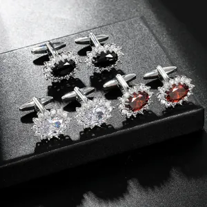 Close-up of luxury crystal cufflinks in black, white, and red set in a premium display case
