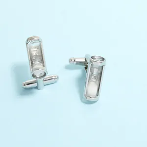 Vue macro détaillée de boutons de manchette sablier en argent avec sable blanc