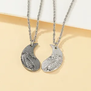 Macro detail of yin yang dragon couple necklaces in silver and black metal finish