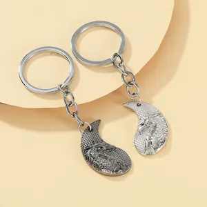 Close-up of interlocking dragon couple keychains in silver and gunmetal finish