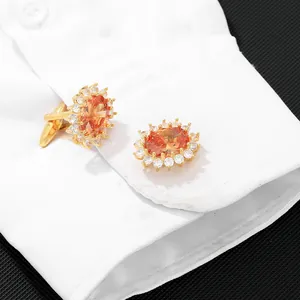 Elegant gold cufflinks with large oval orange crystal and sparkling white halo stones