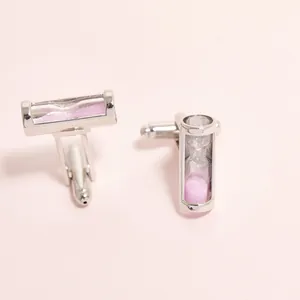 Détails des boutons de manchette sablier argenté avec sable rose sur fond minimal