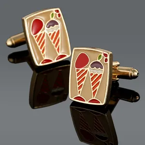 Macro shot of gold-plated ice cream enamel cufflinks with a reflective dark background