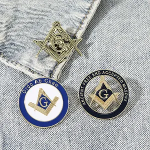 Set of three Masonic lapel pins with Compass and G logo on blue denim fabric background