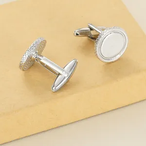 Macro detail of silver round cufflinks featuring knurled edges on a vintage craft box