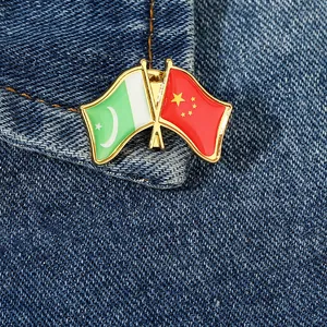 Détail des épinglettes d'amitié Chine-Pakistan sur fond de tissu en jean bleu