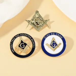 Detailed close-up of three Freemason metal pins with G compass and Ordo Ab Chao symbols