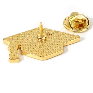 Golden graduation cap brooch featuring a textured back pin and butterfly clutch closure
