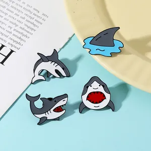 Gros plan de quatre jolies épingles en émail de requin avec une finition polie et thème marin