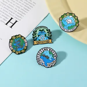 Vue détaillée de quatre pins en émail écologiques avec motifs d'ours polaire, terre et baleine