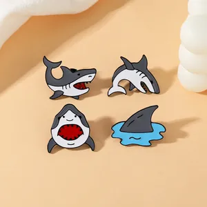 Vue détaillée de quatre pins en émail de requin montrant diverses poses marines