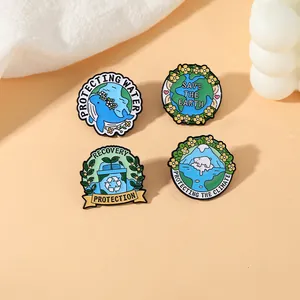 Détail de quatre épinglettes en émail écolo avec des motifs de baleine, terre et ours polaire
