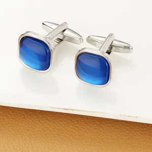 Close-up of square men's cufflinks with blue crystal stones and silver metal finish