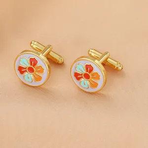 Close-up of vintage round cufflinks with colorful enamel floral pattern on gold metal