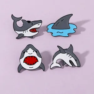 Ensemble de quatre épingles en émail de requin aux poses variées sur fond violet pastel