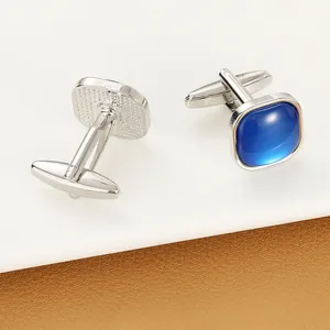 Detail view of square silver cufflinks with blue cat-eye stone and T-bar closure