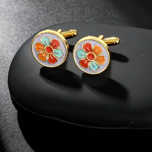 Macro view of vintage round gold cufflinks with colorful floral enamel pattern on black stone
