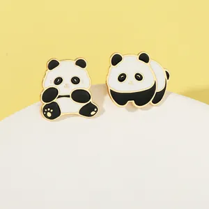 Vue détaillée de deux broches panda mignonnes en émail avec bords dorés sur un support