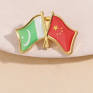 Détail du pin's en émail métallique aux drapeaux croisés du Pakistan et de la Chine dorés