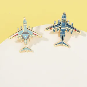 Close-up of enamel fighter jet brooches with blue details on a minimalist display