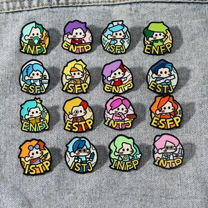 Set of 16 MBTI personality enamel pins in a grid layout on blue denim fabric background