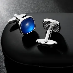 Silver square cufflinks with blue crystal stones on black stones in a premium close-up view
