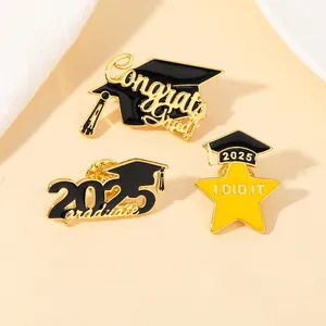 Macro shot of 2025 graduation enamel pins featuring a graduation cap and star badge