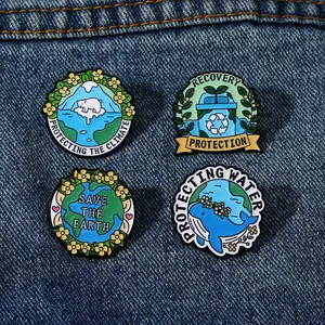 Détail de quatre pins écologiques en émail sur denim avec motifs terre et animaux