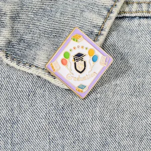 Cute oil painting style graduation enamel pin with graduation cap on blue denim