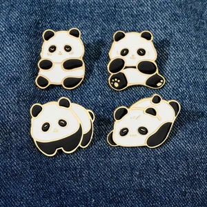 Vue détaillée de quatre pins en émail de panda mignon sur fond de tissu denim bleu