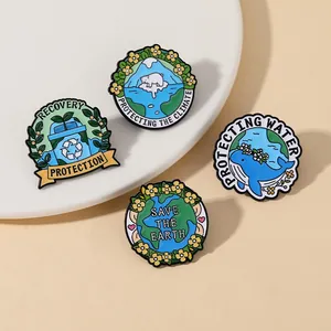 Détail de quatre épinglettes en émail écologiques présentées sur une plaque en céramique