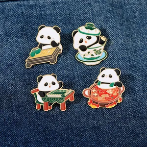 Detailed set of four enamel panda pins showcasing traditional Chinese culture on denim background