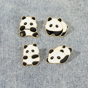 Lot de quatre broches en émail panda mignon dans diverses poses sur tissu denim bleu
