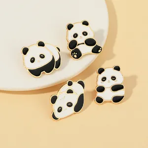 Détail de quatre épinglettes panda en émail avec bordures dorées et poses de dessin animé