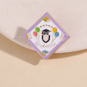 Detail of graduation enamel pin with mortarboard and balloons on golden metal
