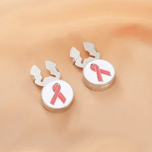 Detail of silver shirt cufflinks featuring round pink ribbon enamel design on satin