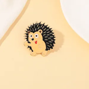 Detail of cute hedgehog enamel brooch with gold alloy edges on a warm orange background
