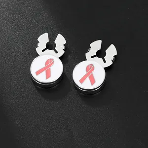Macro detail of silver cufflinks featuring pink ribbon emblem for breast cancer awareness