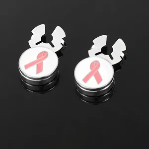 Close-up of polished silver cufflinks with white enamel and pink ribbon awareness symbol