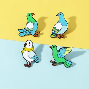 Detailed close-up of four colorful enamel bird brooches with vibrant green and blue pigeon designs