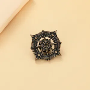 Detailed macro view of vintage bronze anchor brooch with compass and sunburst engraving