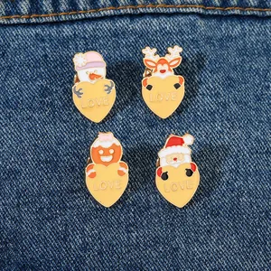 Detail of four Christmas enamel pins with hearts on blue denim fabric background
