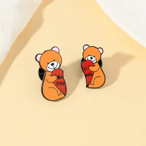 Detailweergave van twee beer-emaille-spelden die een Best Friends-hart vasthouden