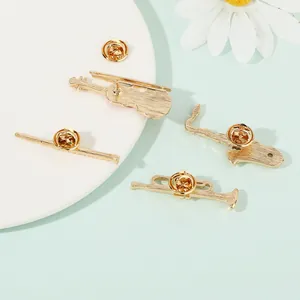 Set of four gold musical instrument pins including violin and sax with butterfly clutches