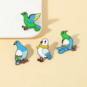 Close-up of four colorful enamel pigeon brooches with vibrant green and blue bird designs