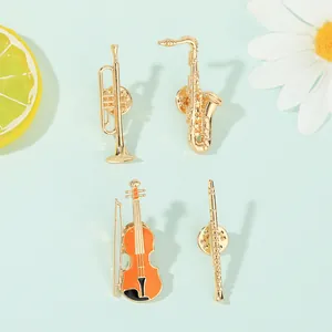 Detailed close-up of musical instrument brooches including violin and saxophone on blue surface