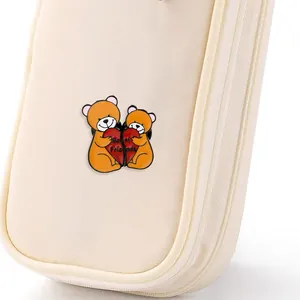 Detail van schattige zinklegering Best Friends beer emaille pins op een crème stoffen tas