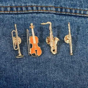 Detail view of musical instrument brooches on denim featuring trumpet and saxophone