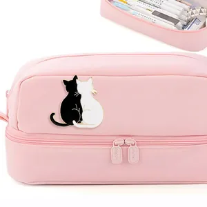 Enamel black and white cat brooch in heart shape pinned on a pink zipper pencil case