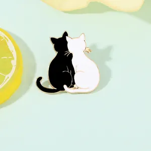 Detail of a heart-shaped cat enamel brooch with gold trim on a lemon background